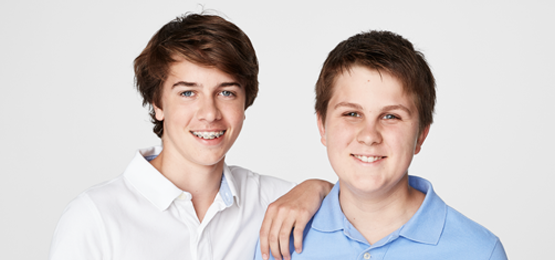 Two young males smiling to camera