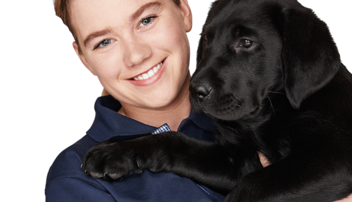 Staff member holding a seeing eye dog puppy 