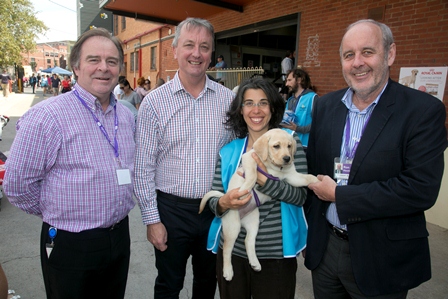 Photo of Leigh Garwood, Hon Martin Foley, volunteer Blandina holding Silver the puppy and CEO Ron Hooton