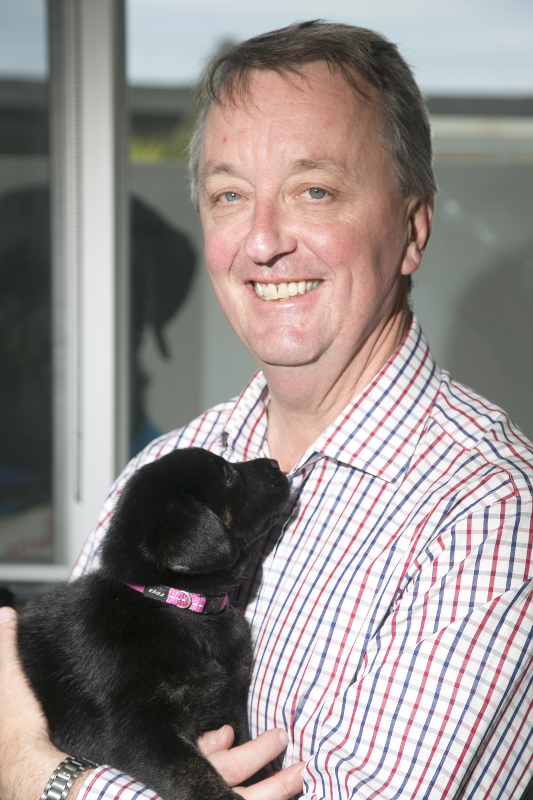 Minister Foley holding a black labrador puppy