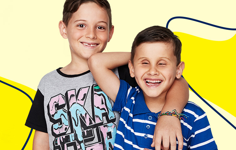 A boy is smiling and has his arm around the shoulder of his brother.
